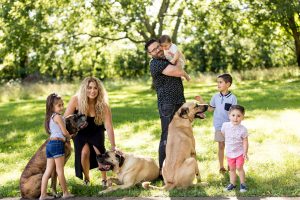 A photo of Danny Gokey, his family and his dogs in a lush field | Celebrity Dogs and Their People by Sara Kauss